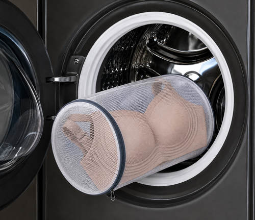 HugMyBody Mesh Laundry Bag with a zippered closure, containing a Brown HugMyBody™ Signature Jelly Bra and shown inside an open front-loading washing machine.